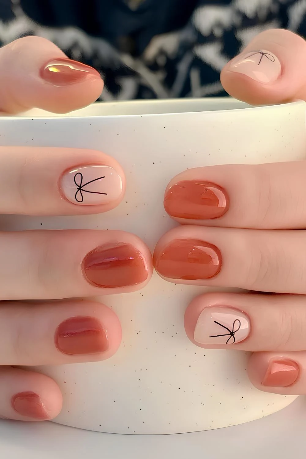 Burnt orange nails with bow art