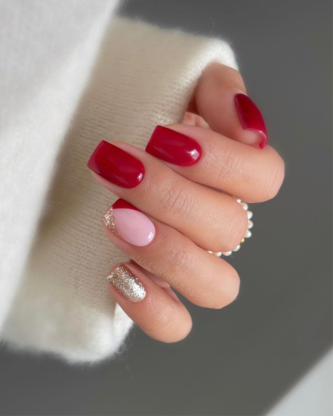 Classic red nails with glittery gold accents