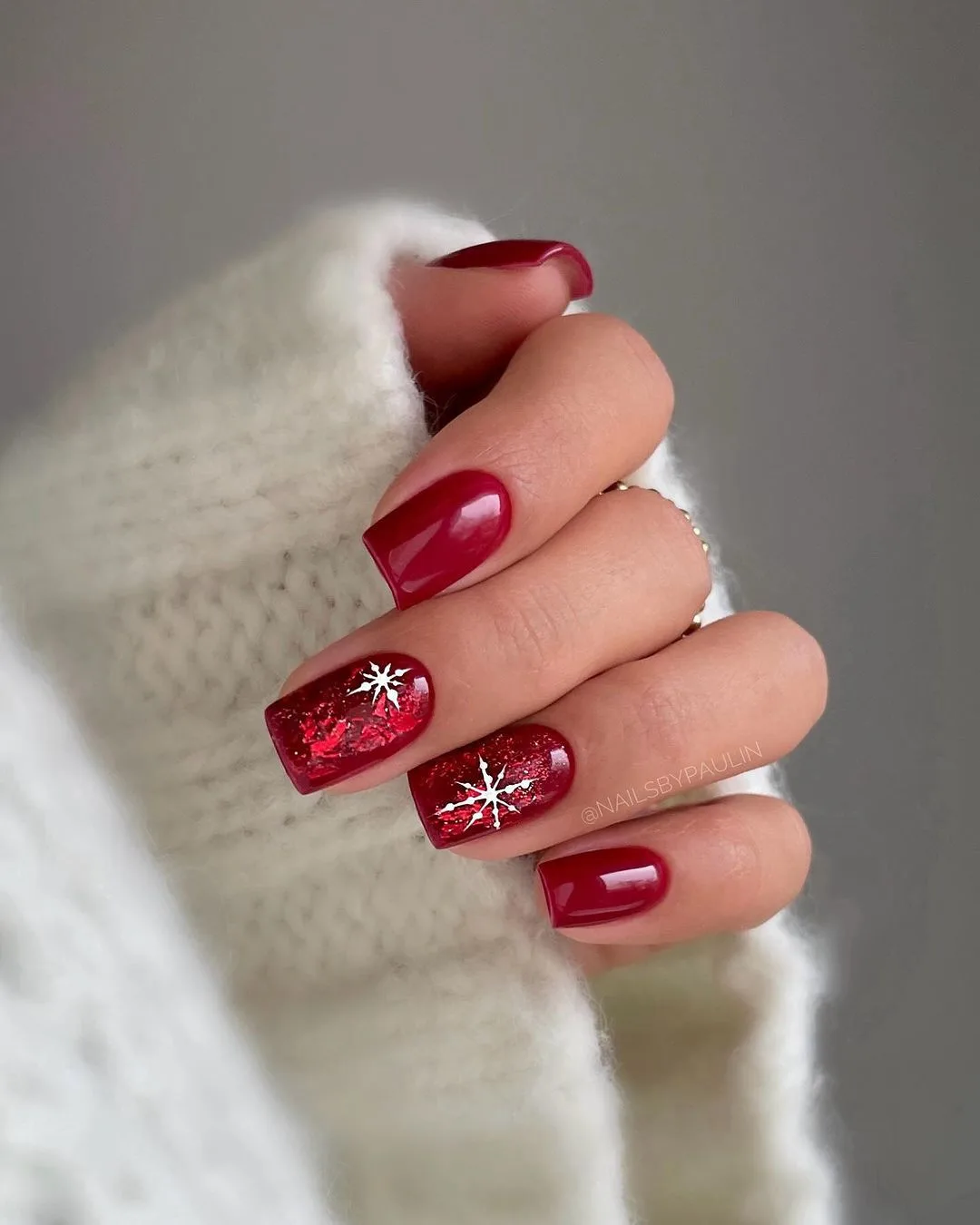 Glitter red nails with subtle snowflake details