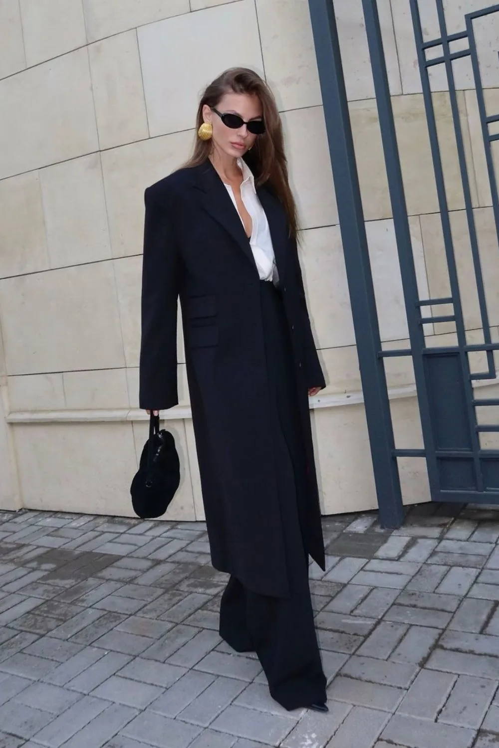 Long black blazer with black pants paired with white shirt