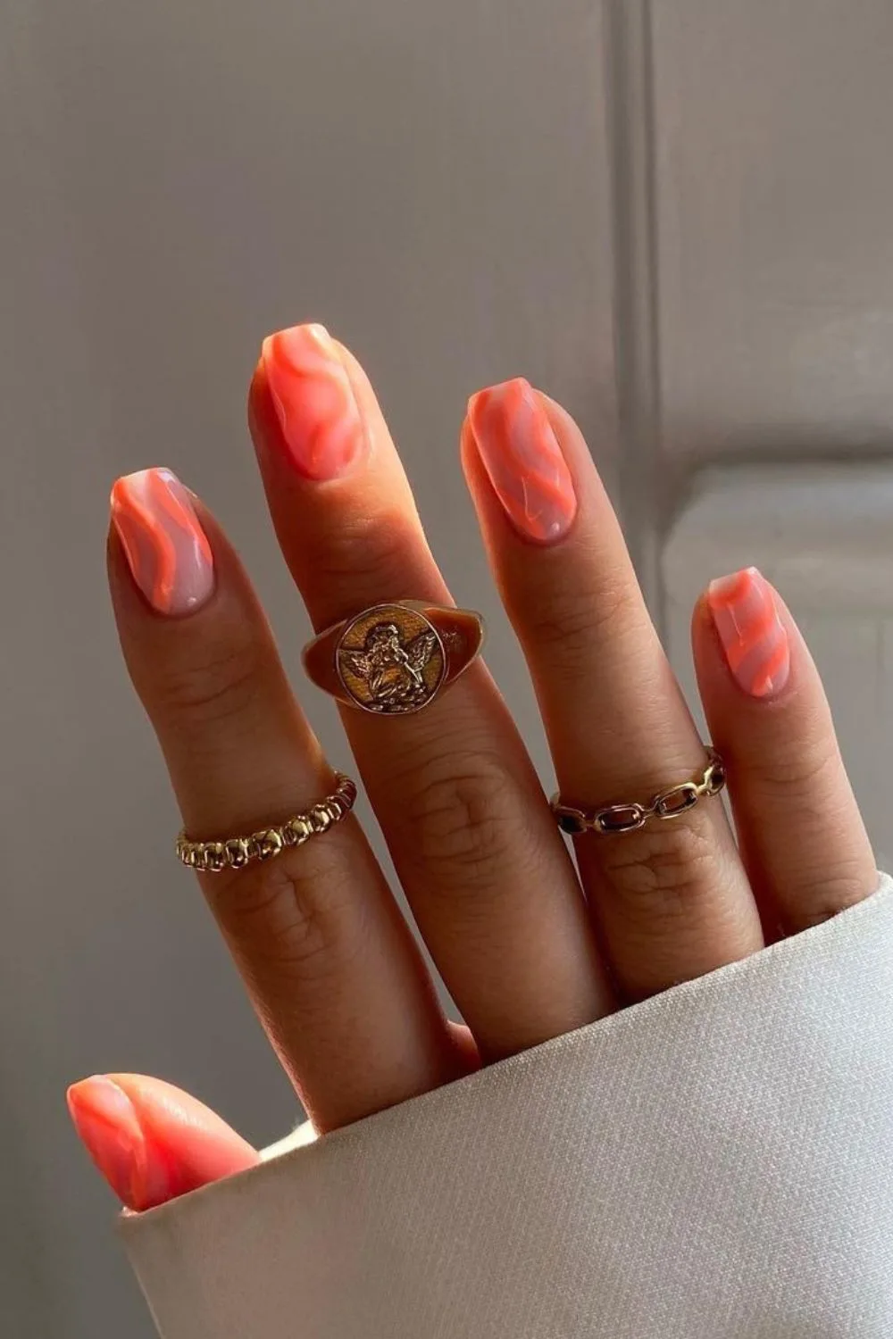 Nude nails with neon peach swirls