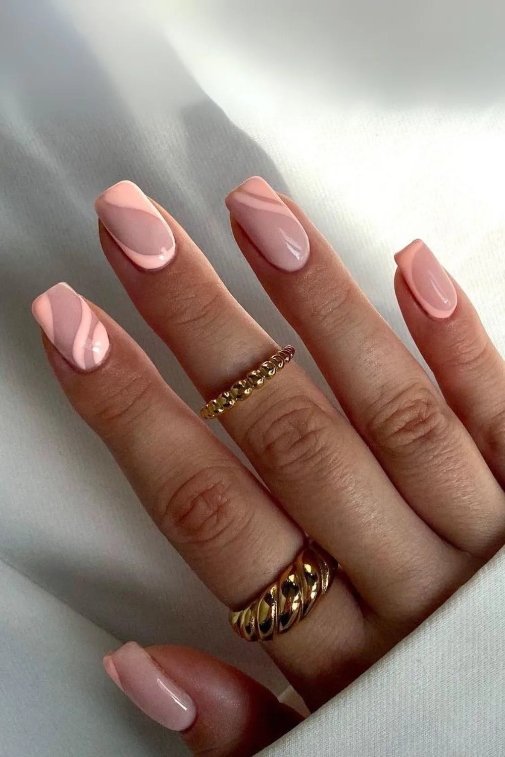 Nude nails with peach fuzz swirls