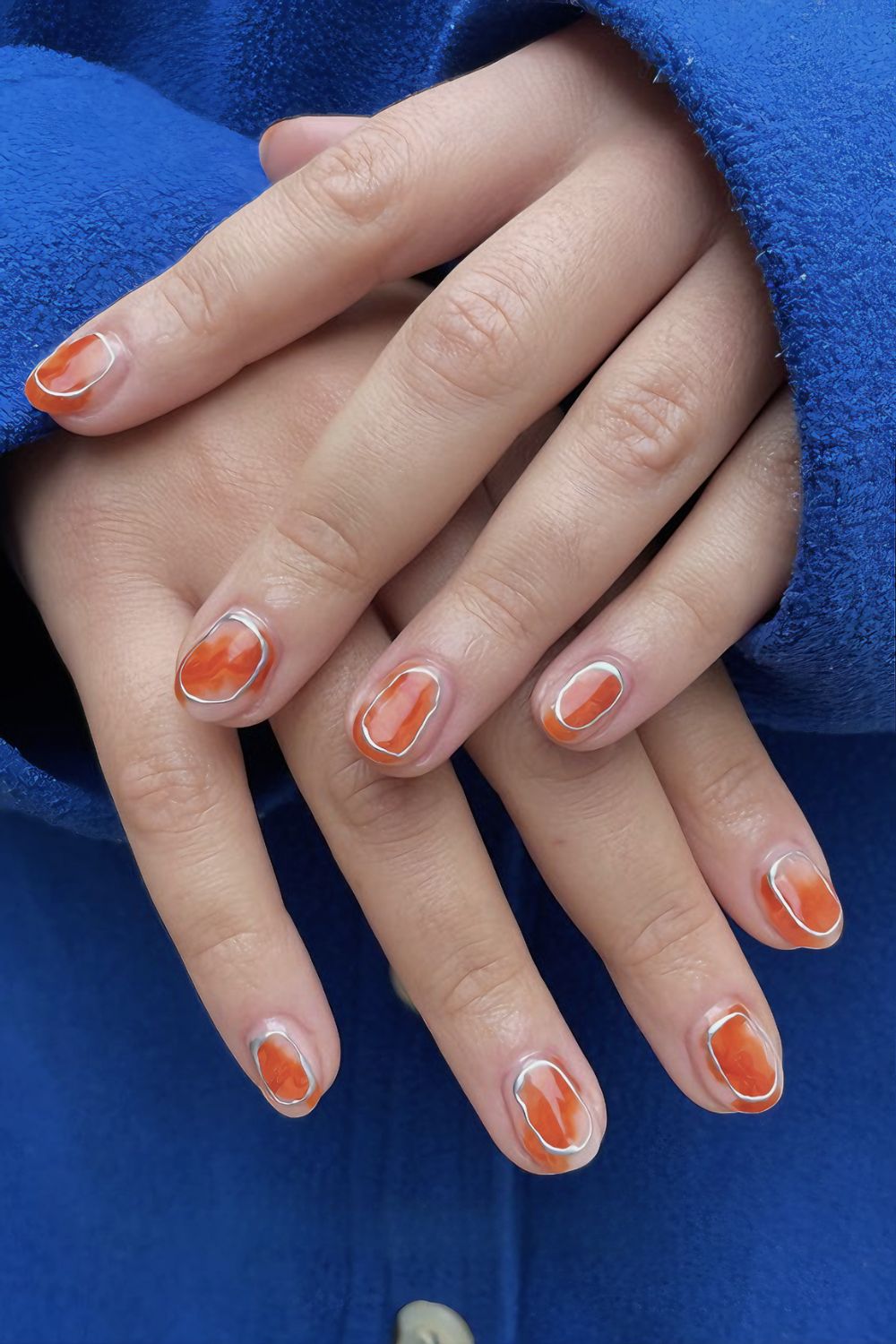 Orange aura nails with silver chrome rings