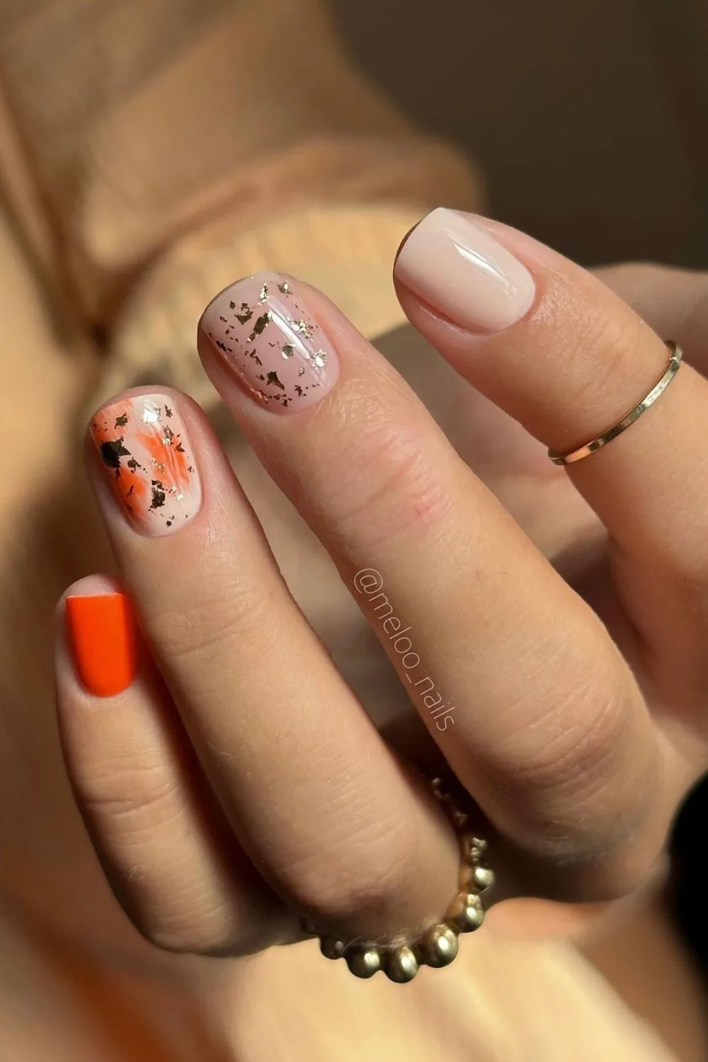 Orange nails with gold accents