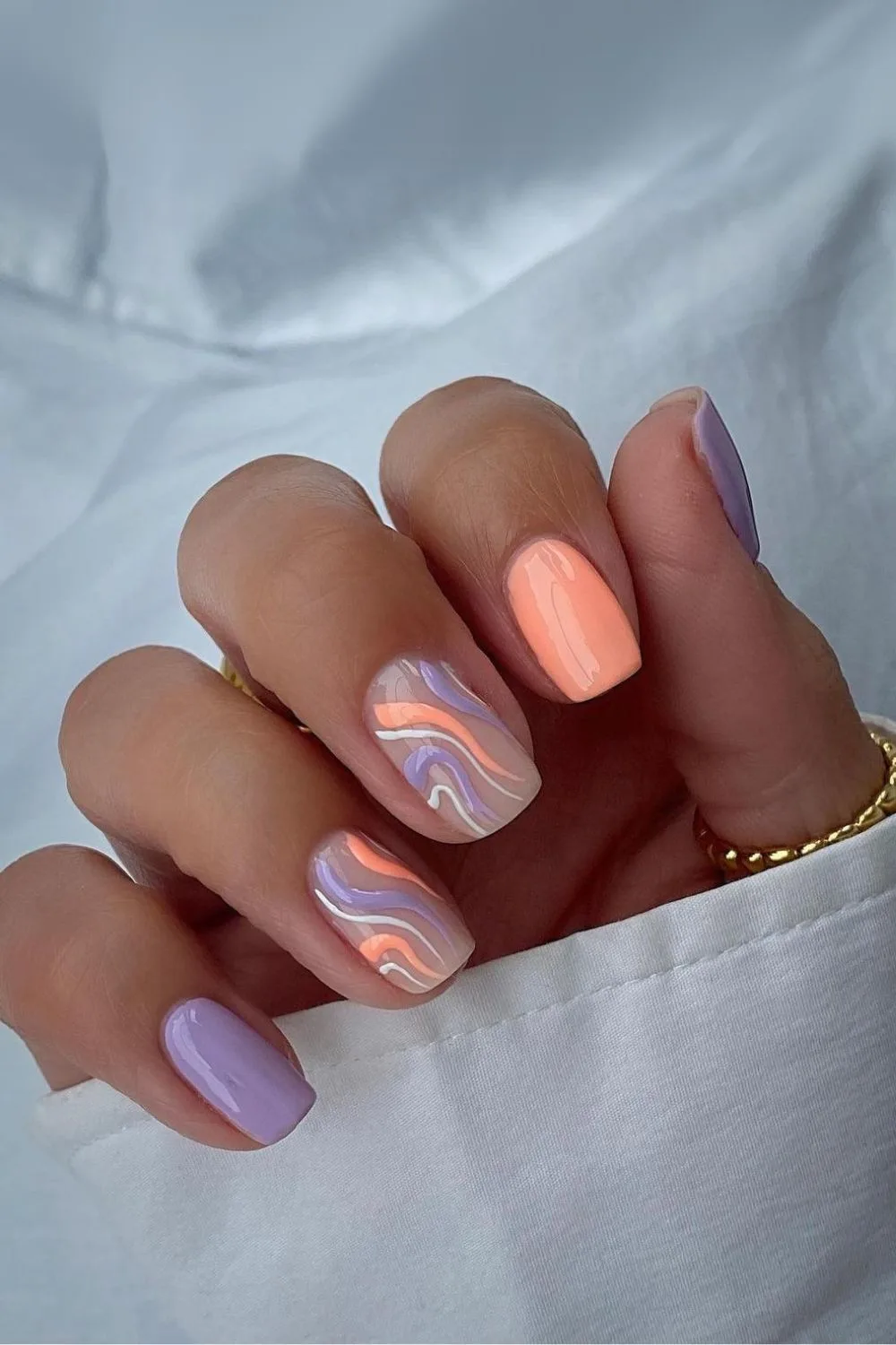 Peach and purple nails with swirls