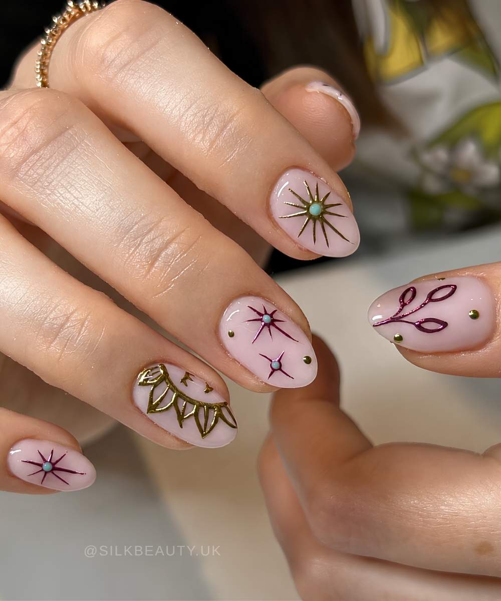 Pink nails with metallic sun and star art