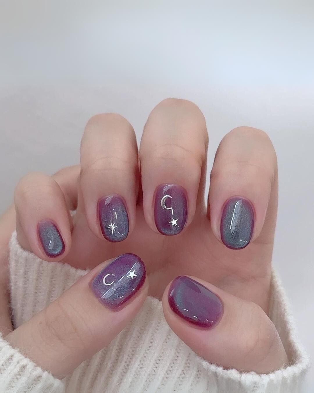 Purple and blue cat eye nails with celestial charms