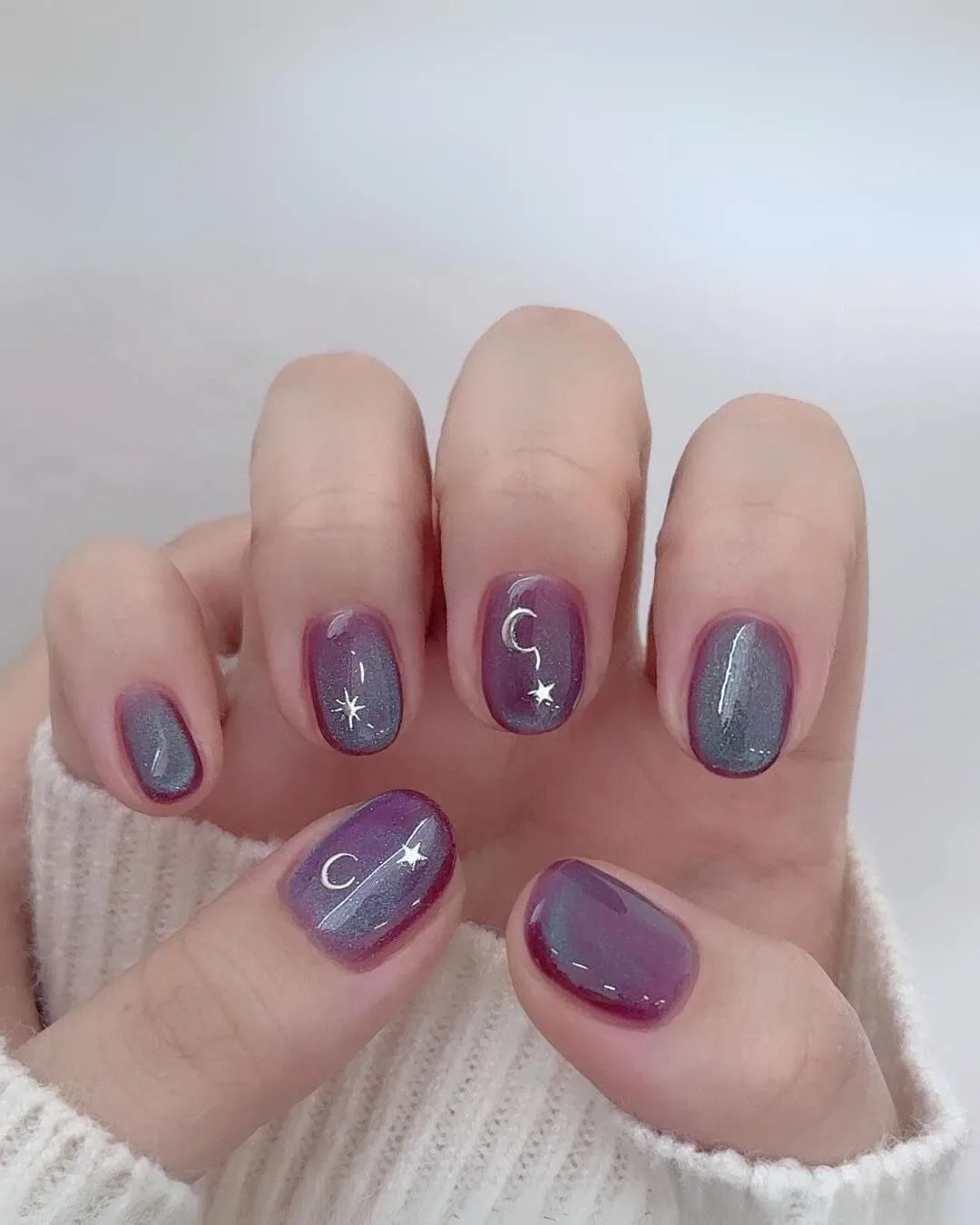 Purple and blue cat eye nails with celestial charms