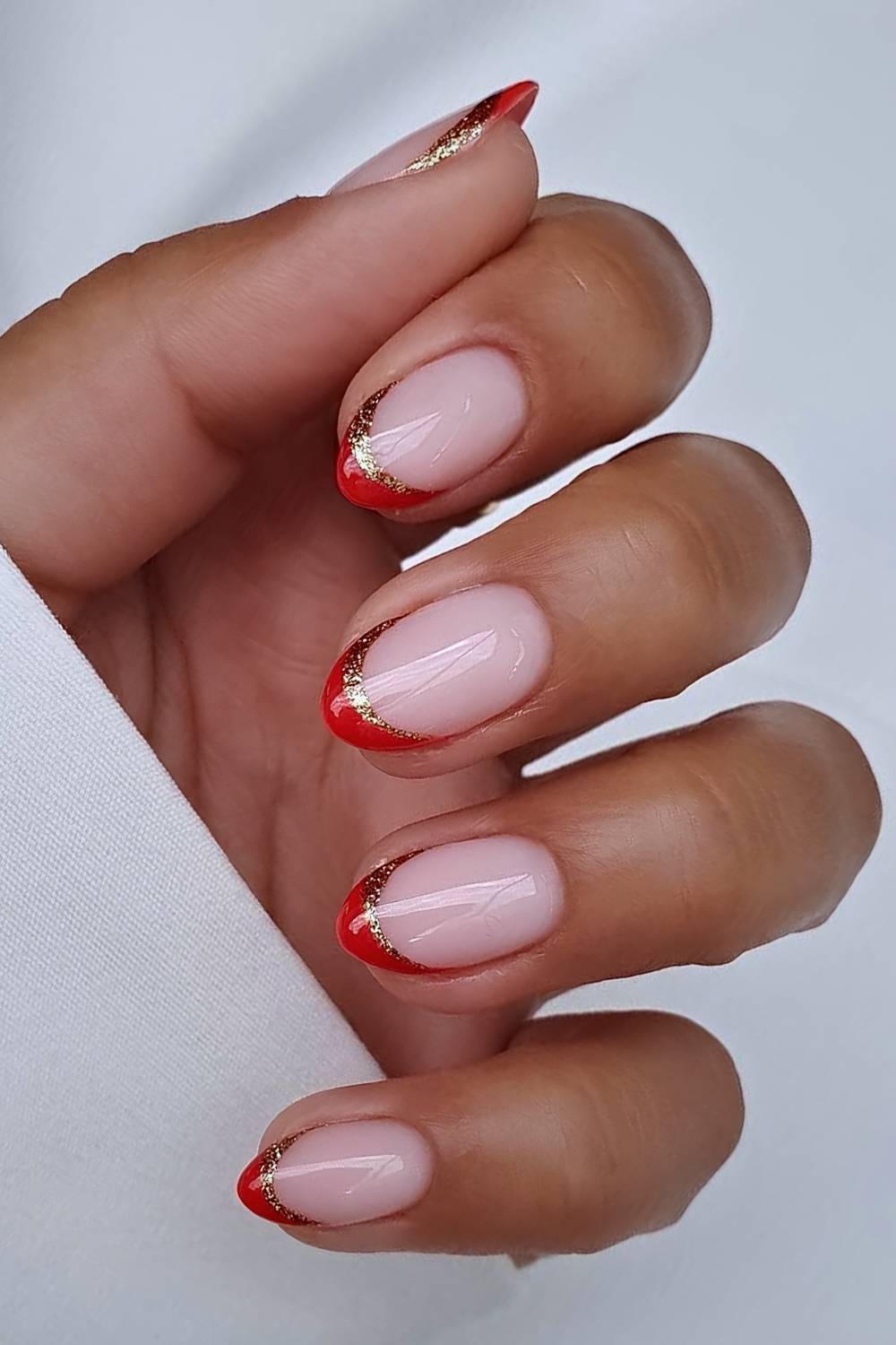 Red French mani with gold glitter outlines