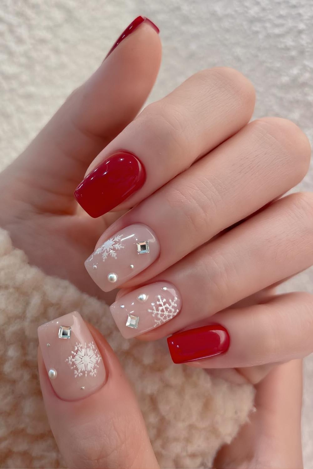 Red and white nails with rhinestones and snow art