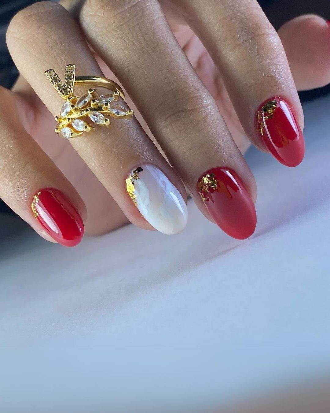 Red nails with white accent and gold details