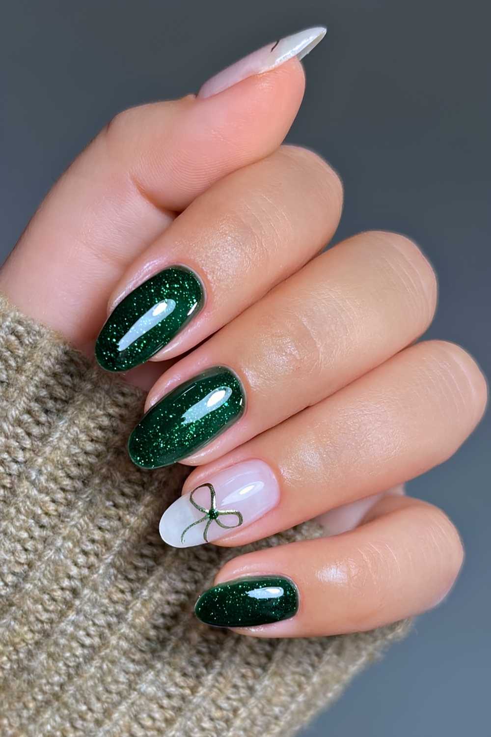 Shimmery dark green mani with coquette bow