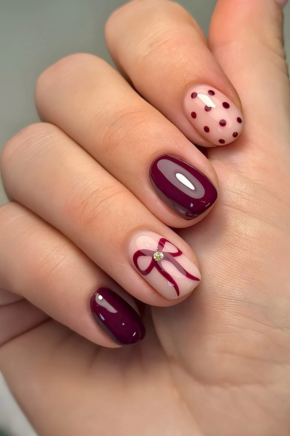 Short burgundy nails with bows and polka dots