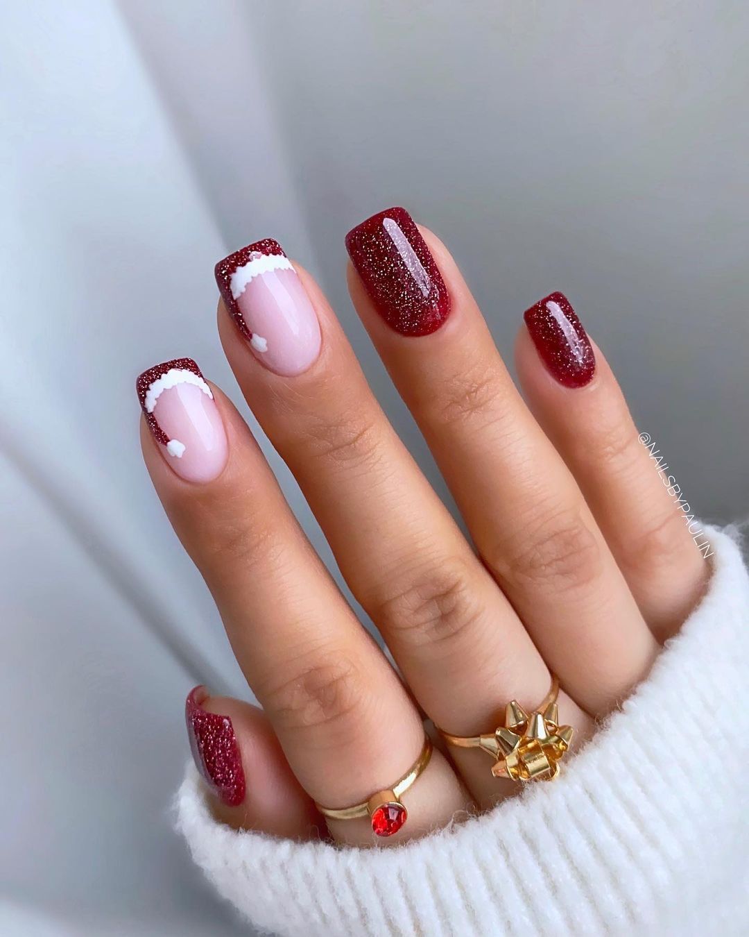 Short burgundy nails with santa hat accents