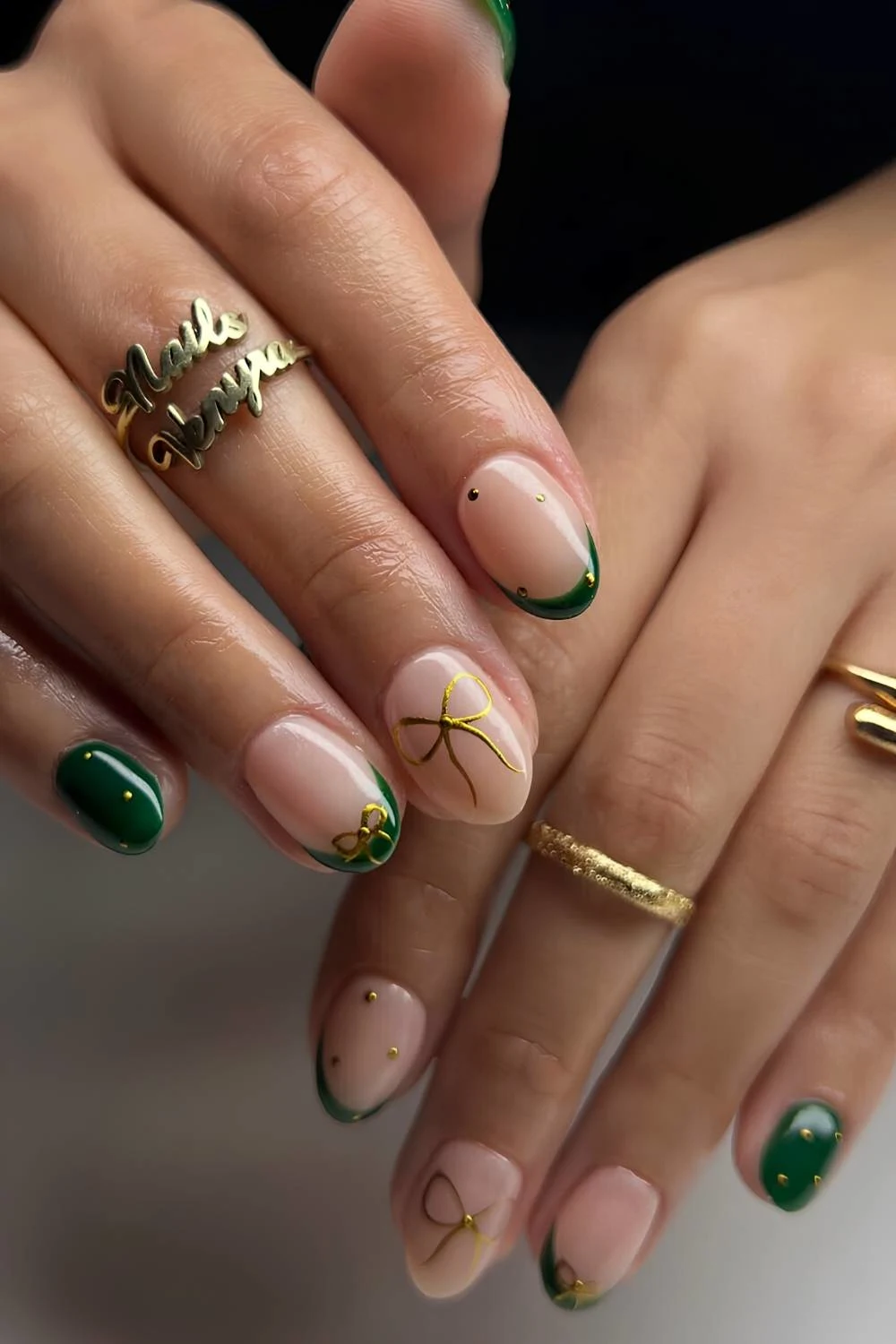 Short dark green nails with gold chrome bows