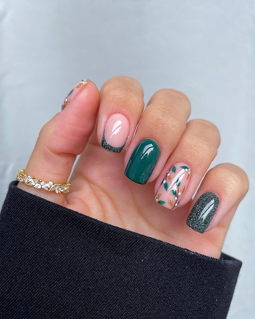 Short emerald and glitery green nails with mistletoe accent