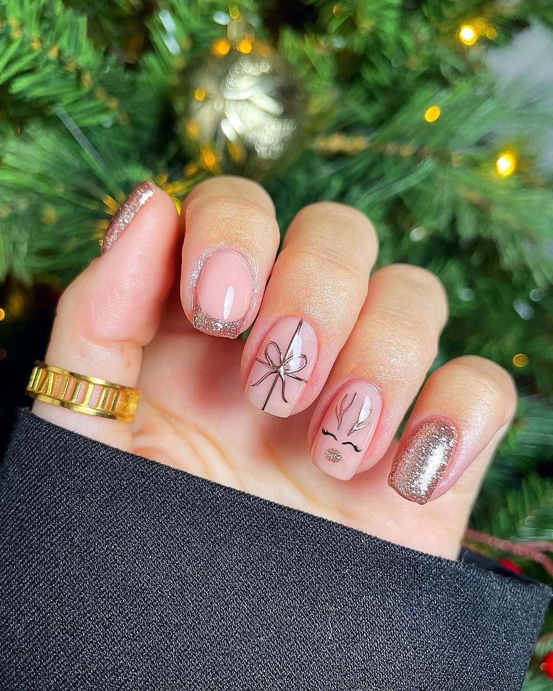 Short glittery gold French tips with reindeer and gift bow design