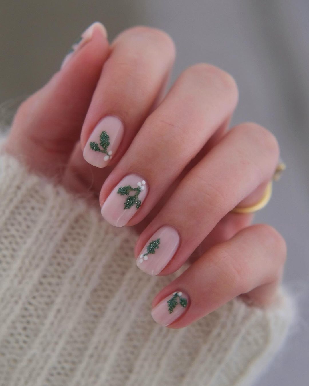 Short pink nails with green glittery holly details