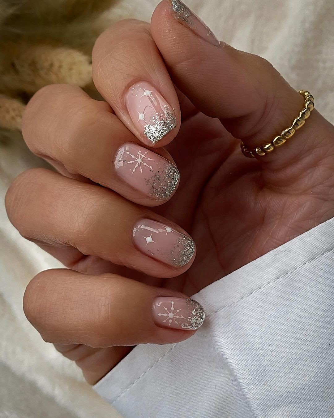 Silver glitter snowflakes on nude nails