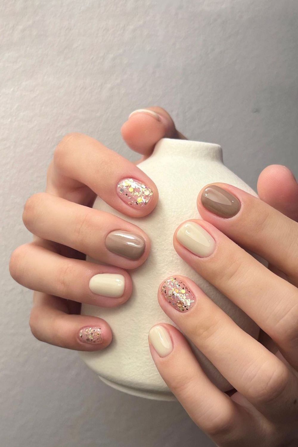 Taupe and vanilla nails with glitter accents