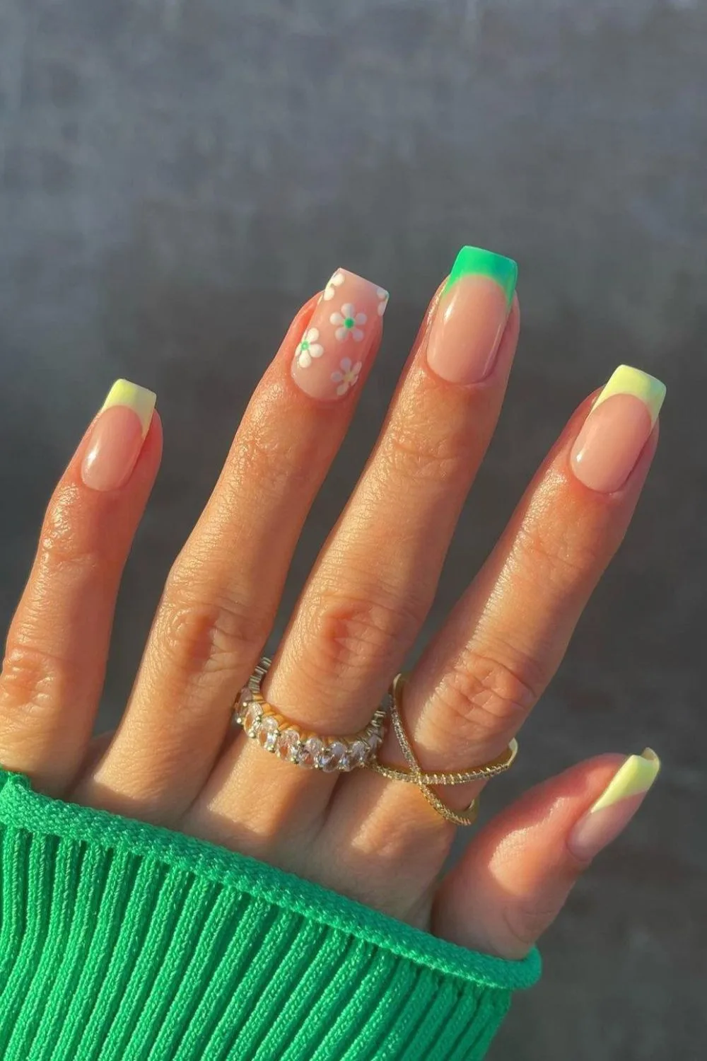 Vibrant green French nails with daisy accents