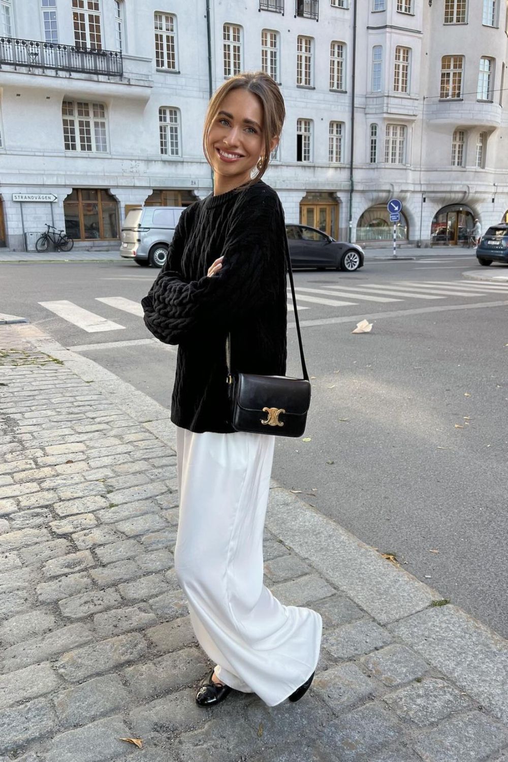 black knit sweater paired with white pants