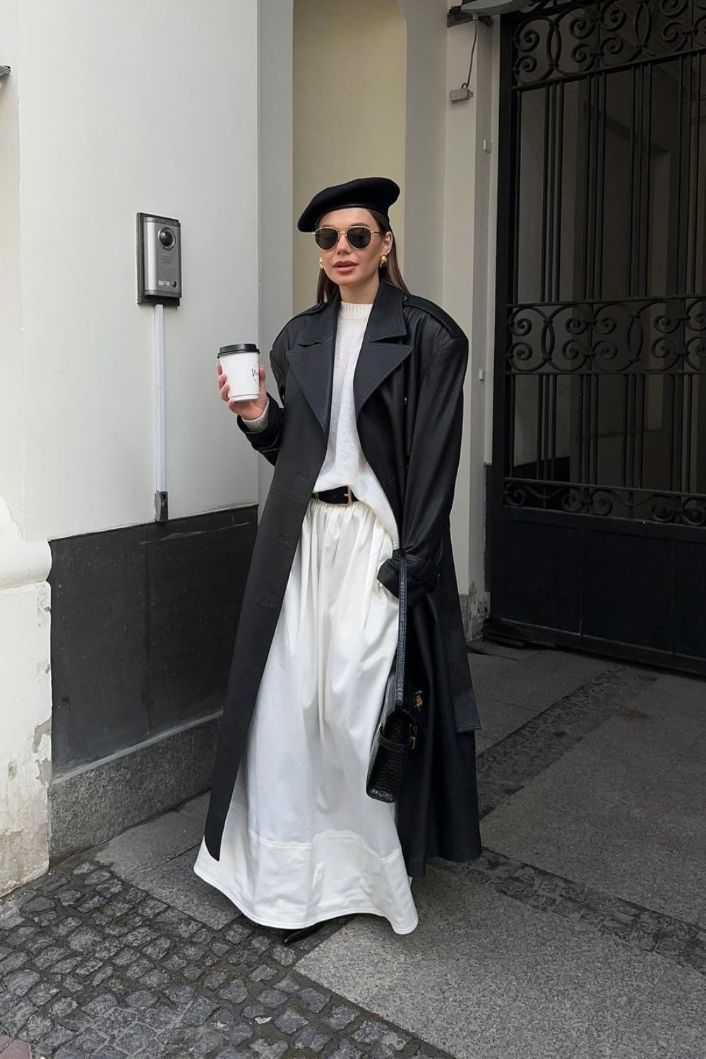 black leather maxi coat with maxi white skirt and a black beret