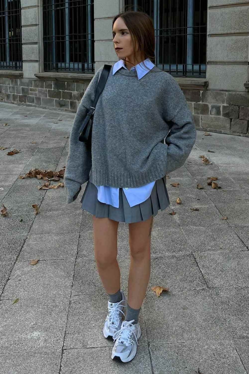 gray sweater over blue oxford shirt with pleated mini skirt