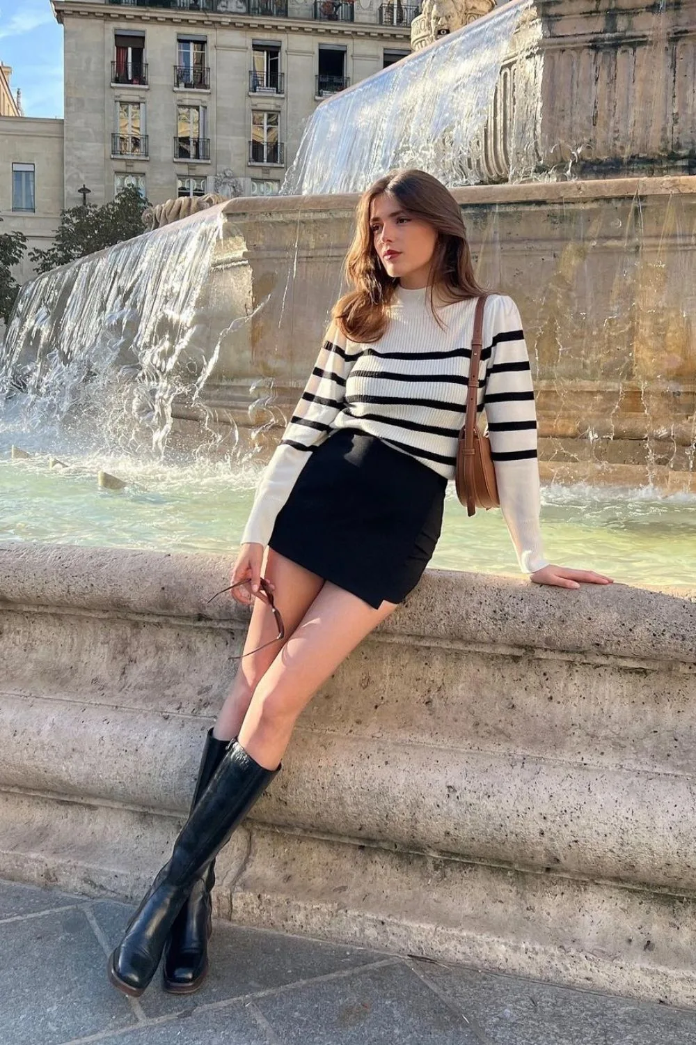 striped sweater and black mini skirt paired with boots