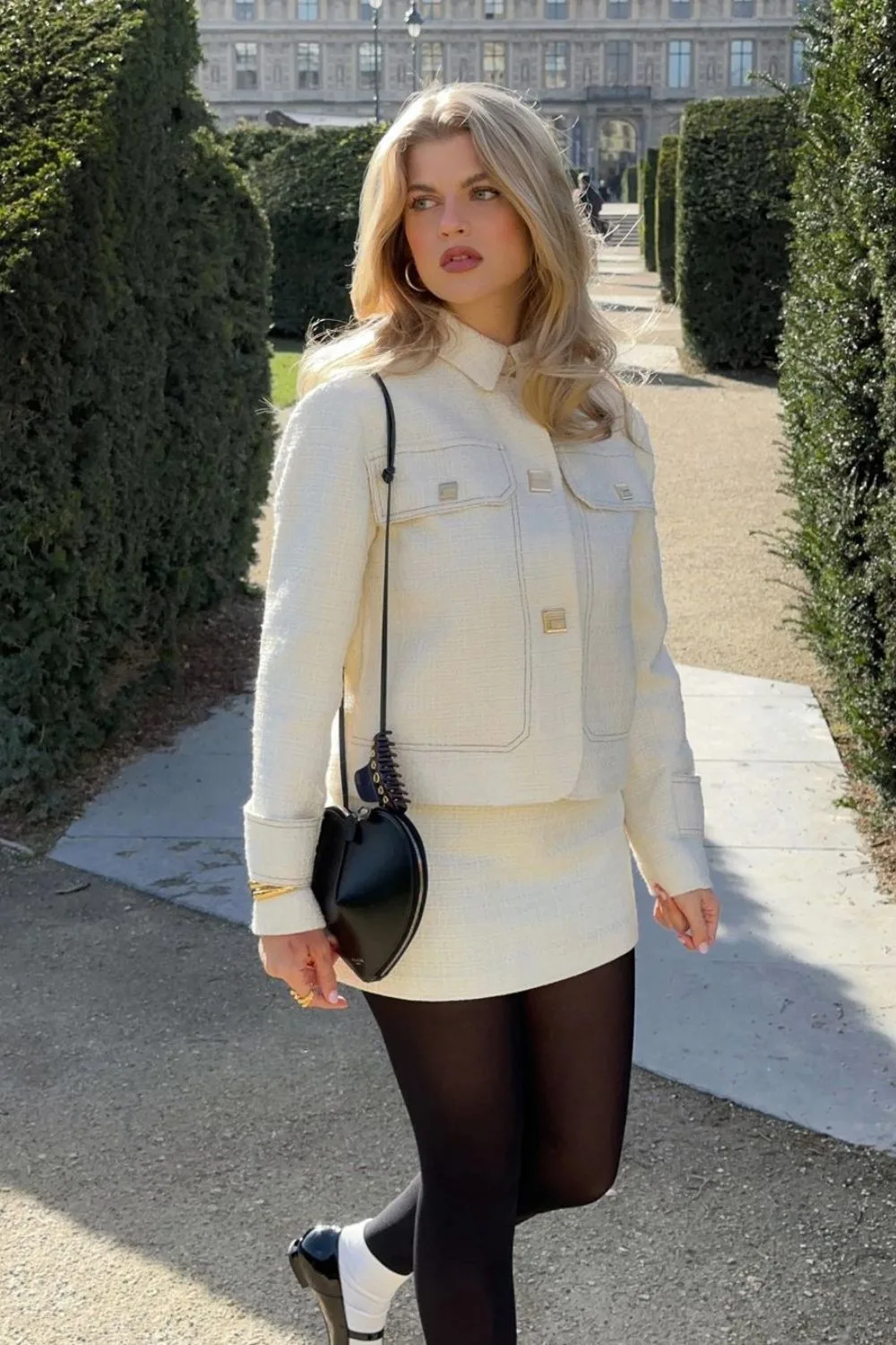 white tweed jacket and mini skirt with black heart bag