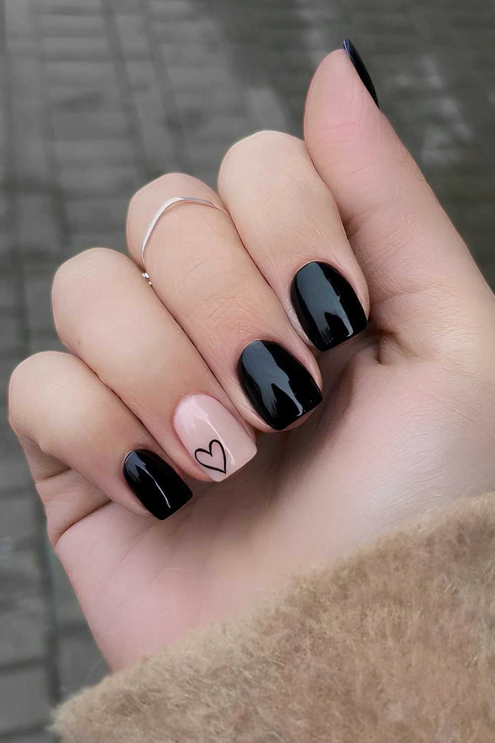 Black nails with a heart on an accent nail