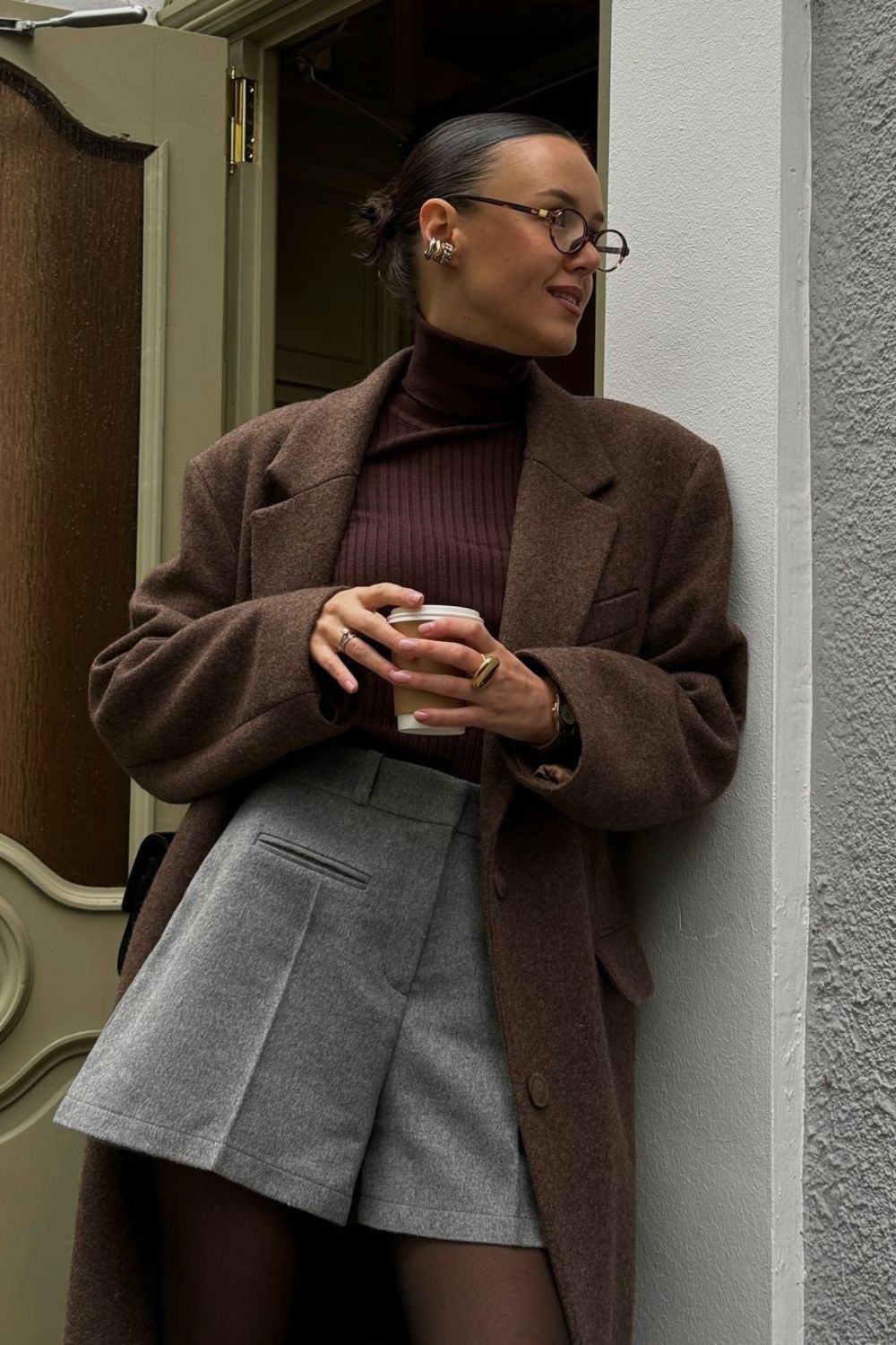 Brown oversize coat with brown turtleneck and gray shorts