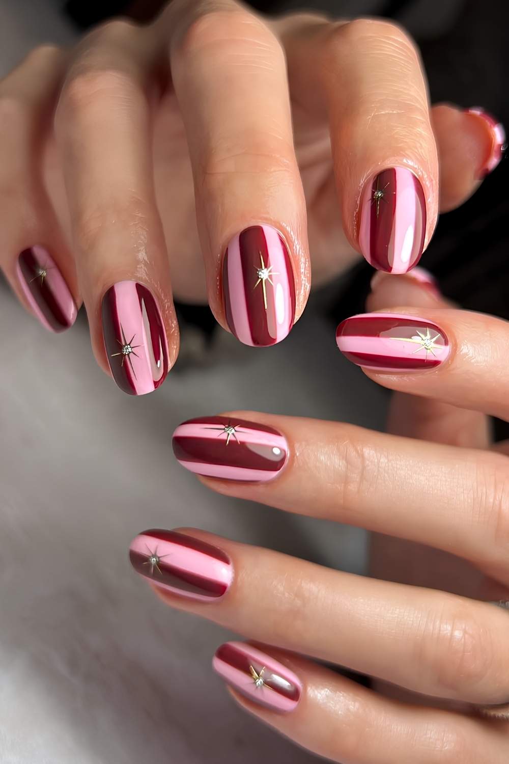 Burgundy and pink striped Christmas nails
