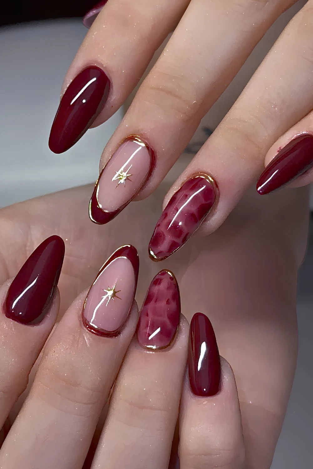 Burgundy nails with animal print and gold accents