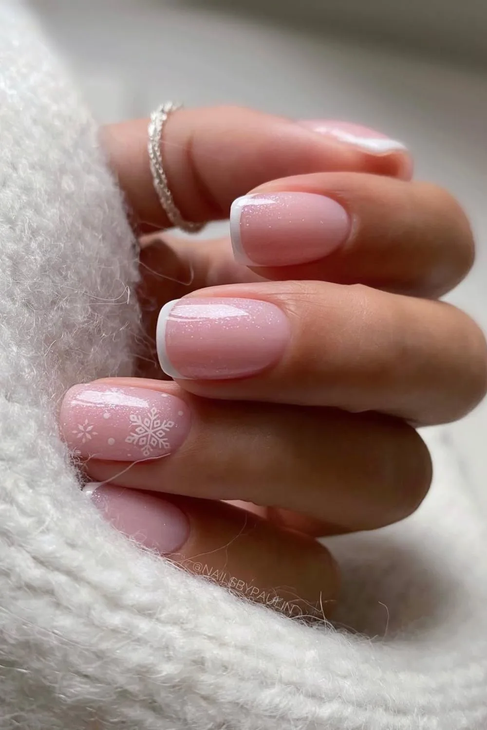 Classic French tip nails with snowflake accentClassic French tip nails with snowflake accent