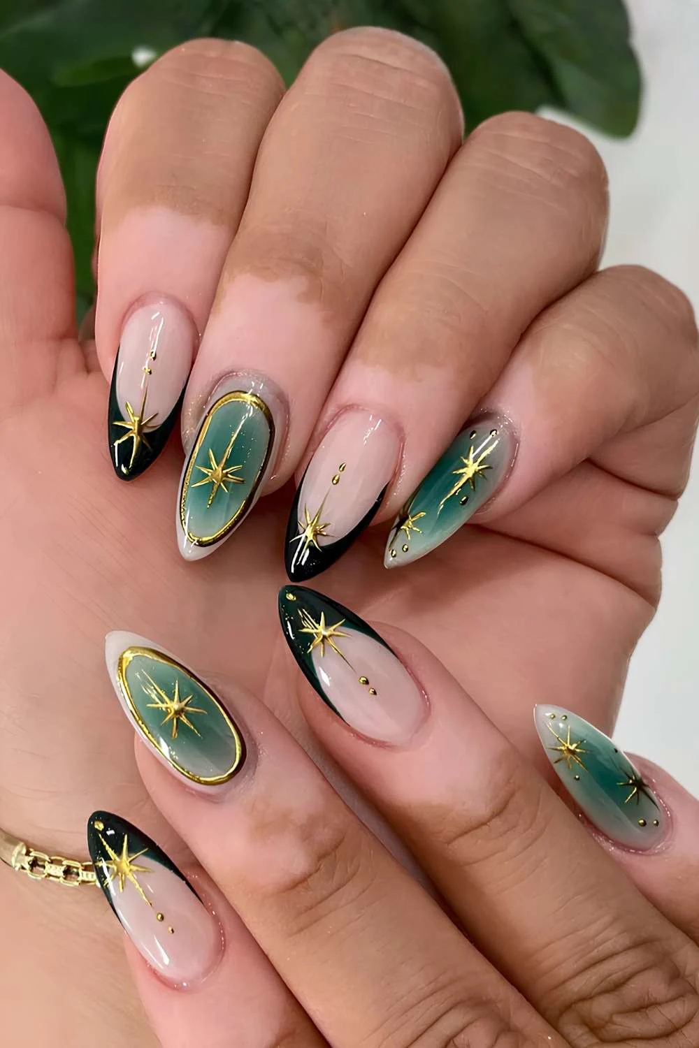 Dark green French mani with gold stars and outlines