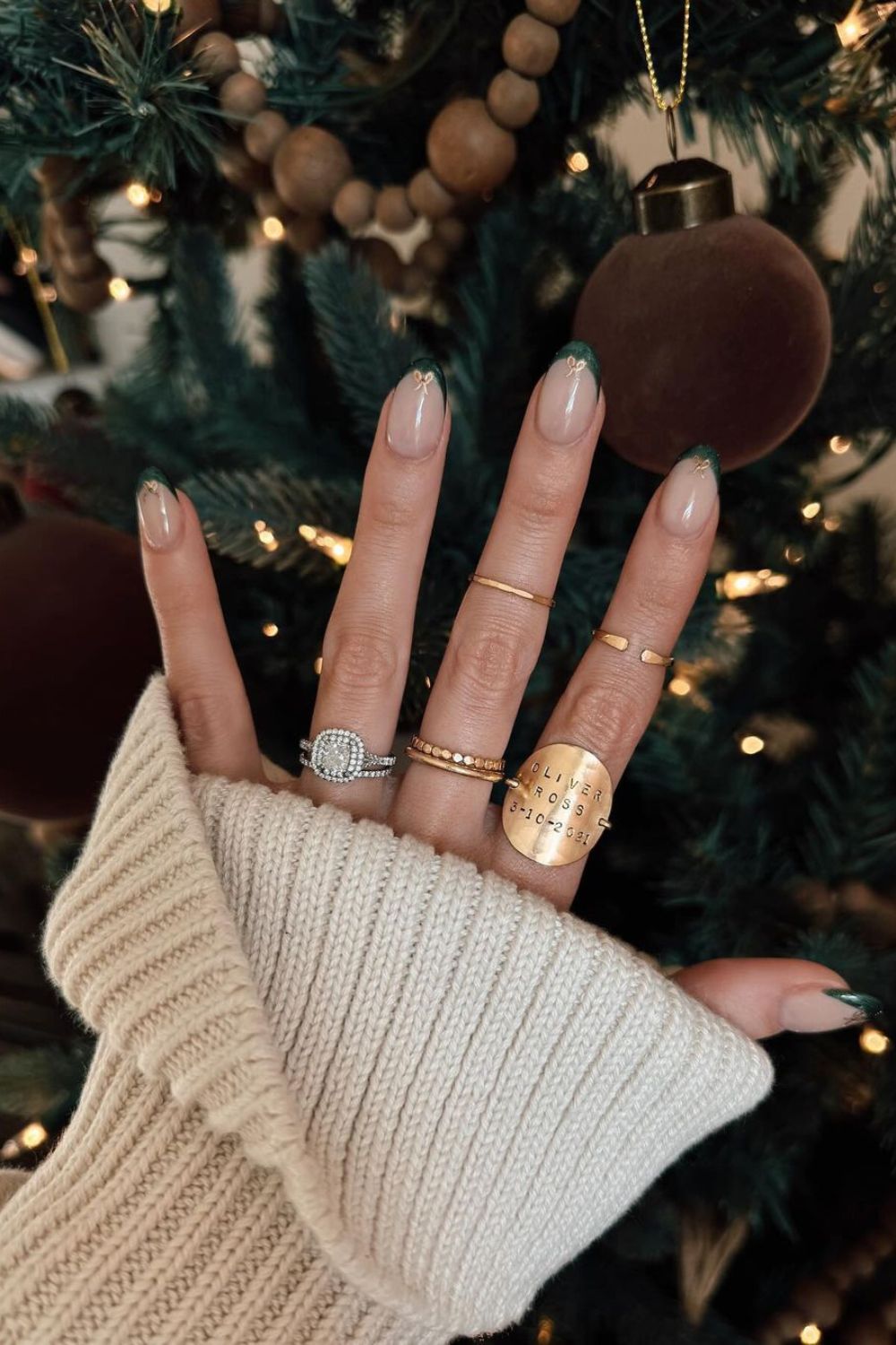 Deep green french tip nails with tiny golden bows