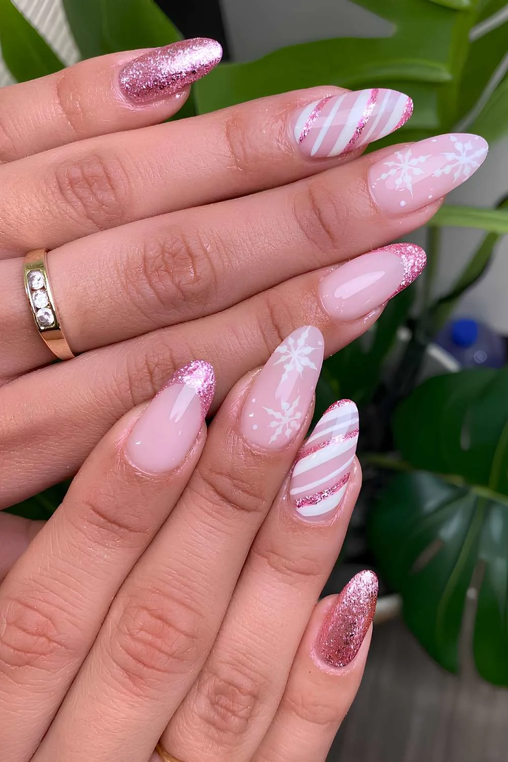 Glittery pink nails with snowflakes and candy swirl art