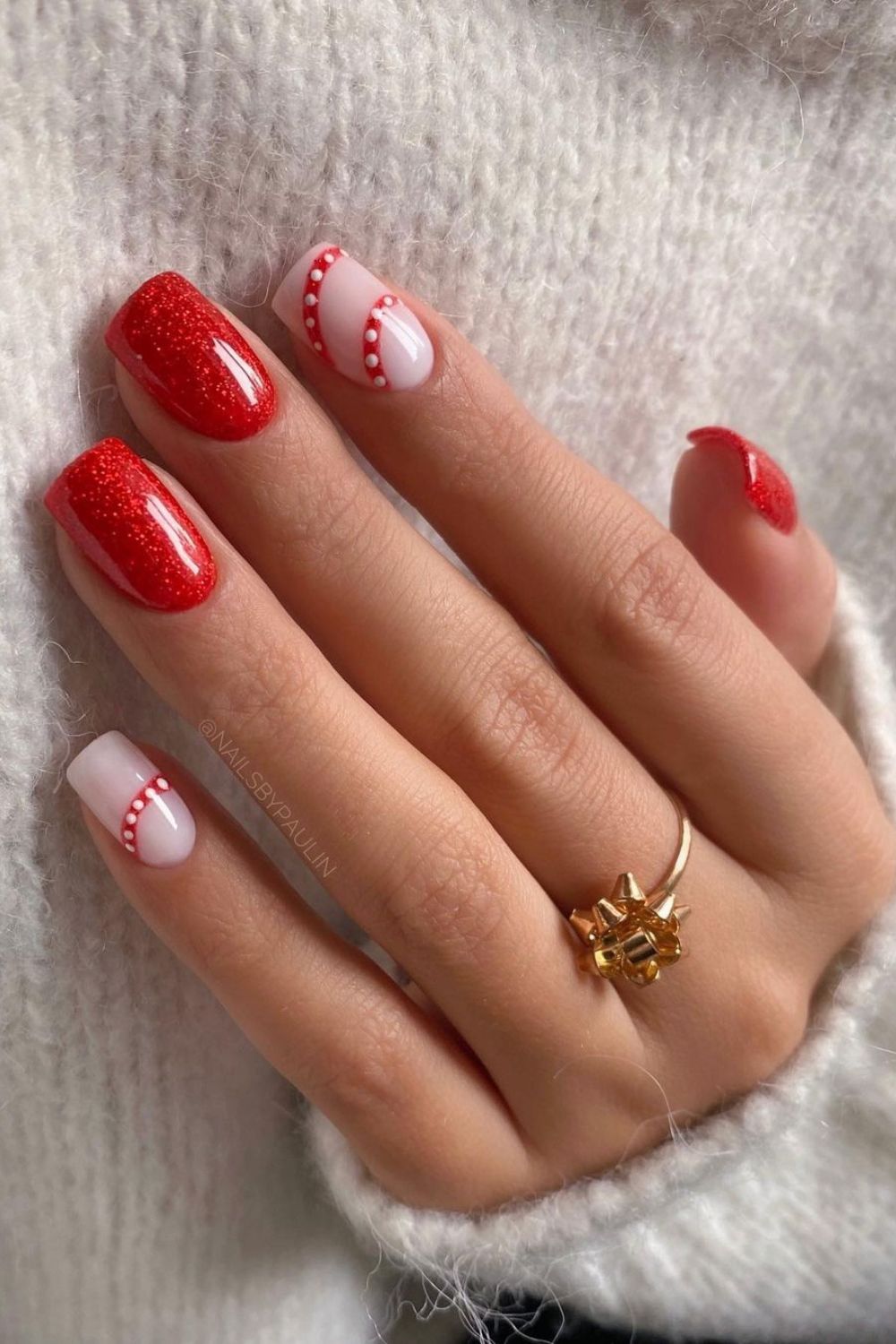 Glittery read and milky white nails with candy cane pattern details