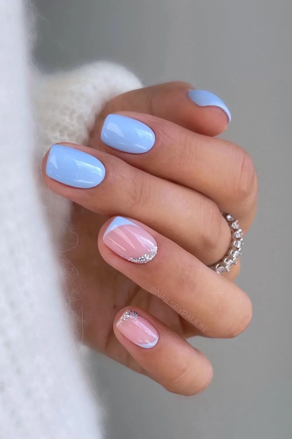 Light blue nails with silver glitter accents