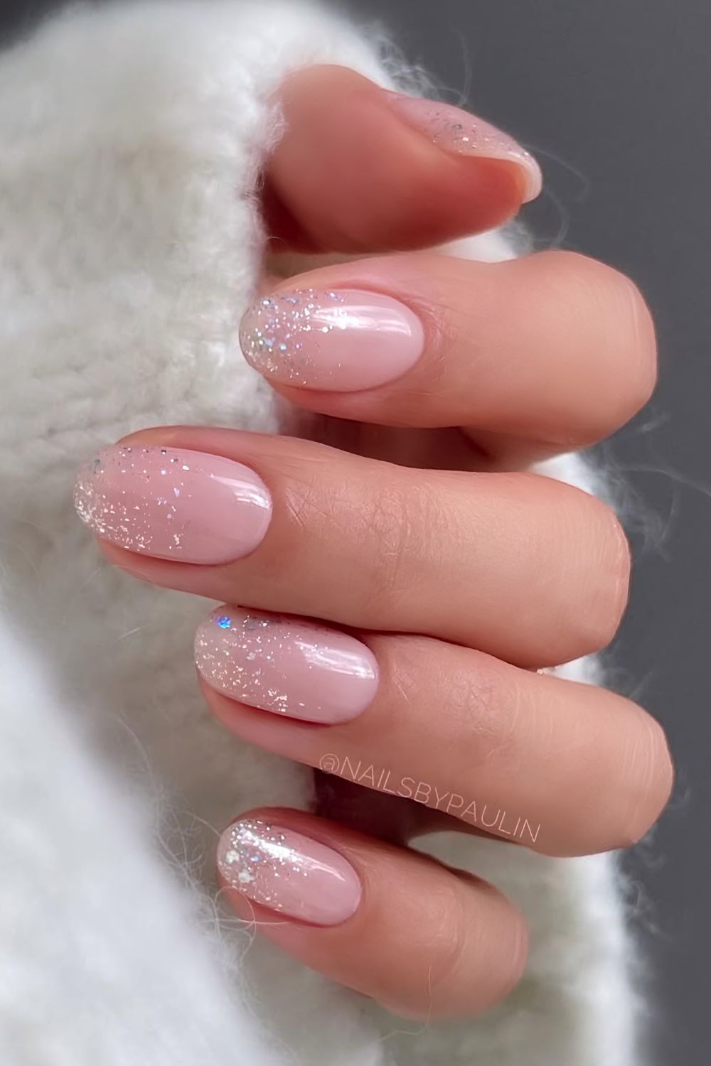 Milky pink nails with glitter ombre accent