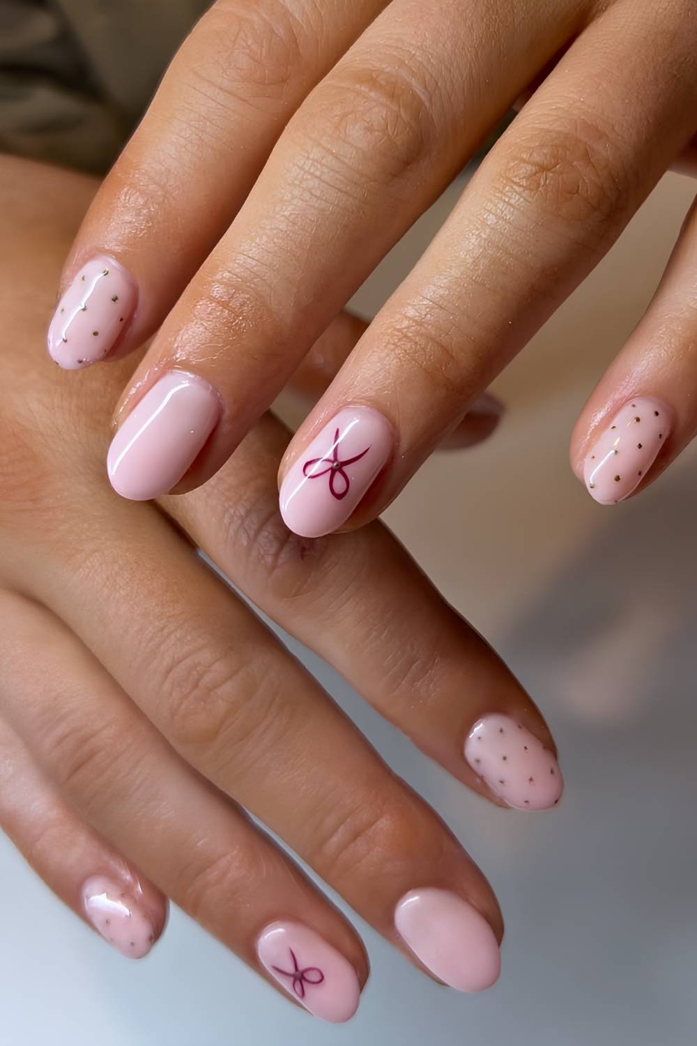 Milky pink nails with polka dots and bow art