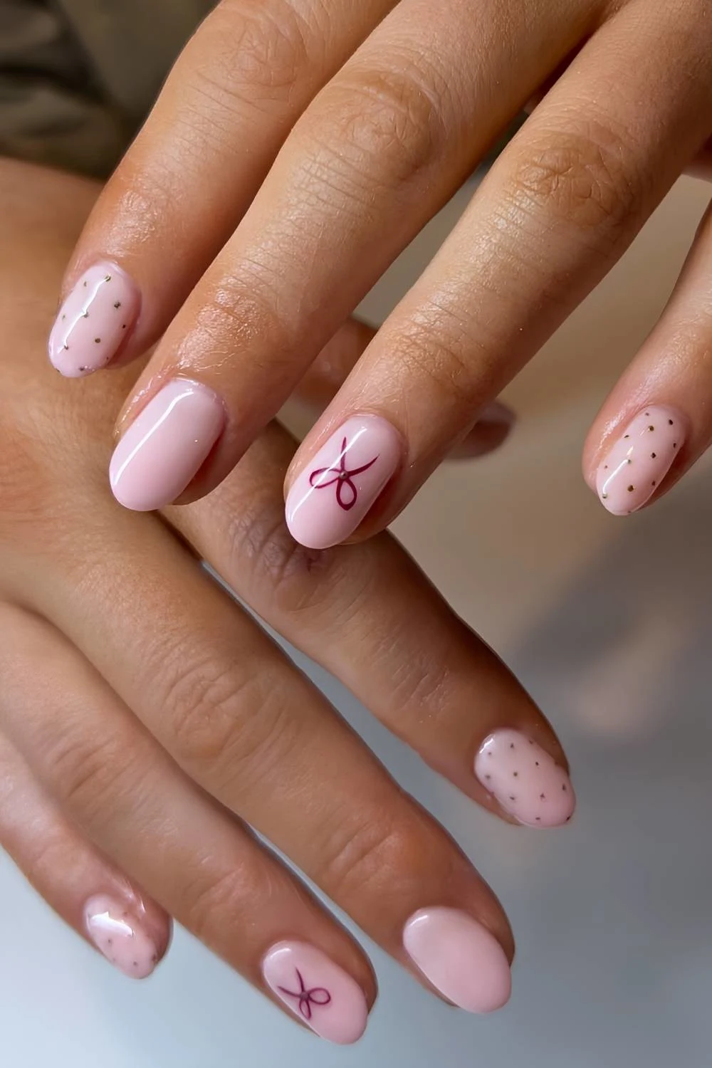 Milky pink nails with polka dots and bow art