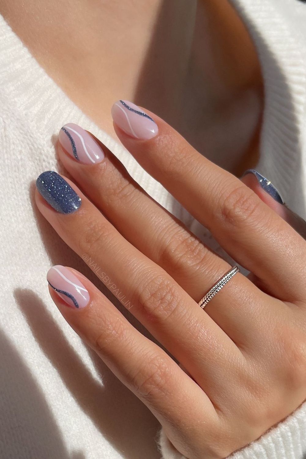 Milky white nails with glittery blue swirls