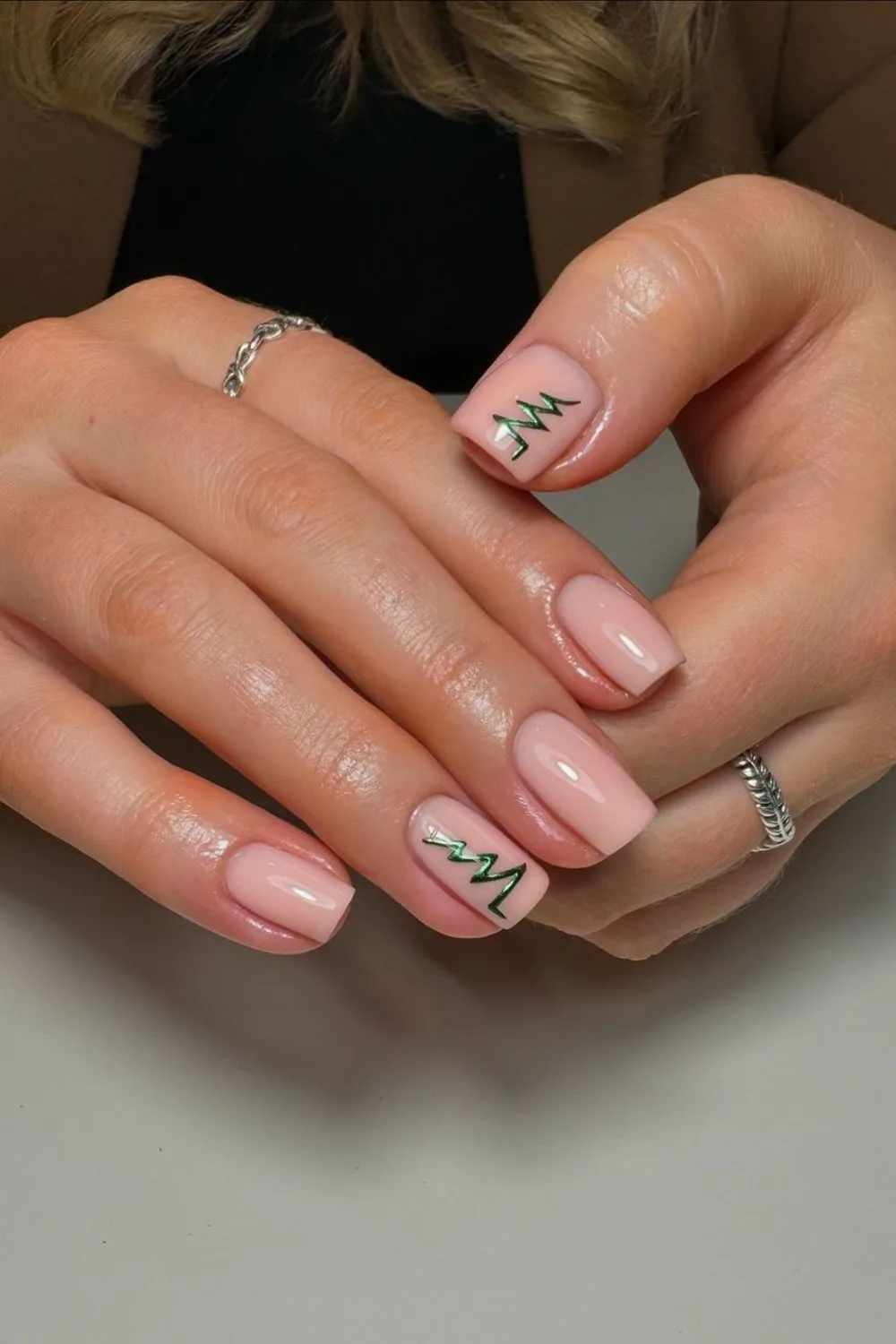 Neutral nails with tiny green Christmas tree accent