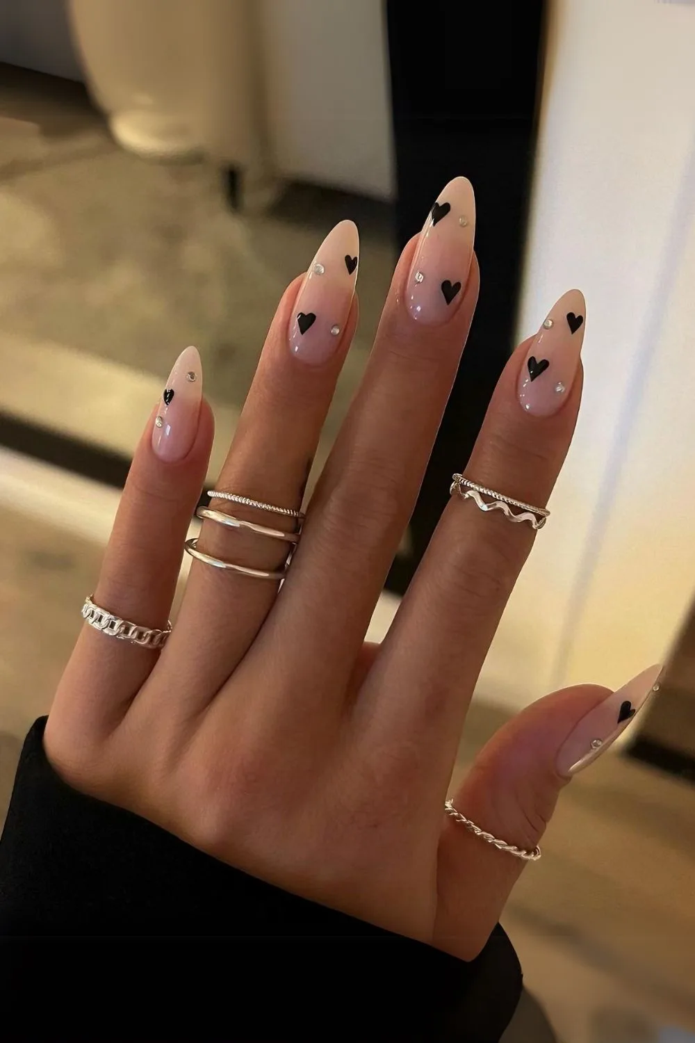 Nude nails with black hearts and rhinestones