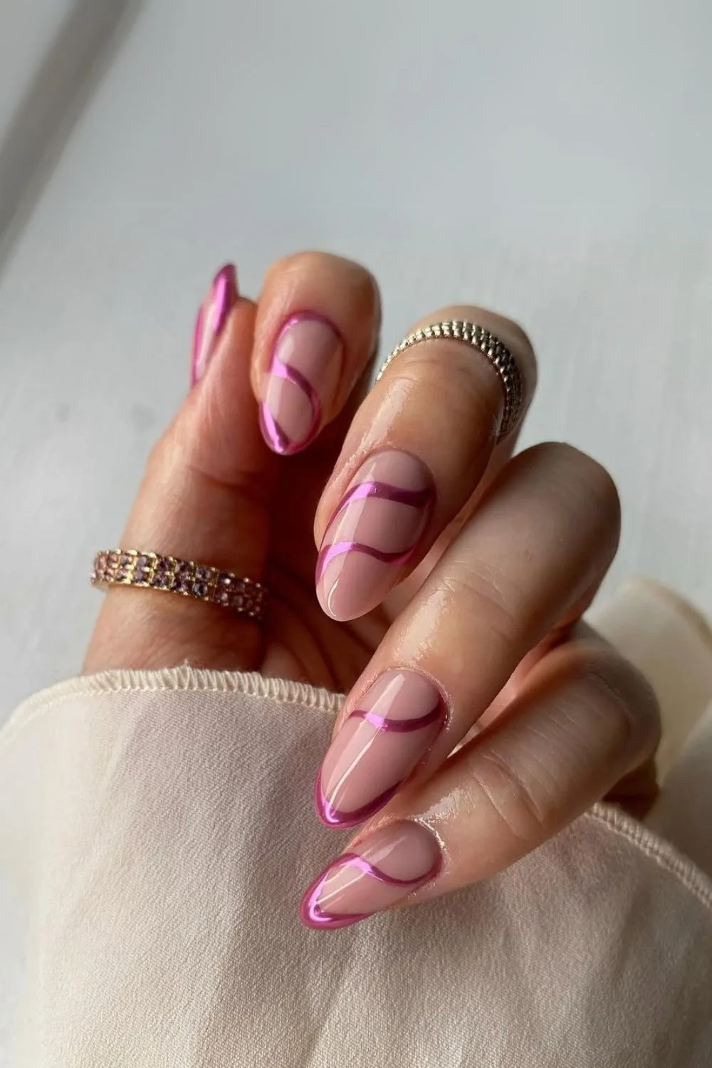 Nude nails with pink chrome swirls