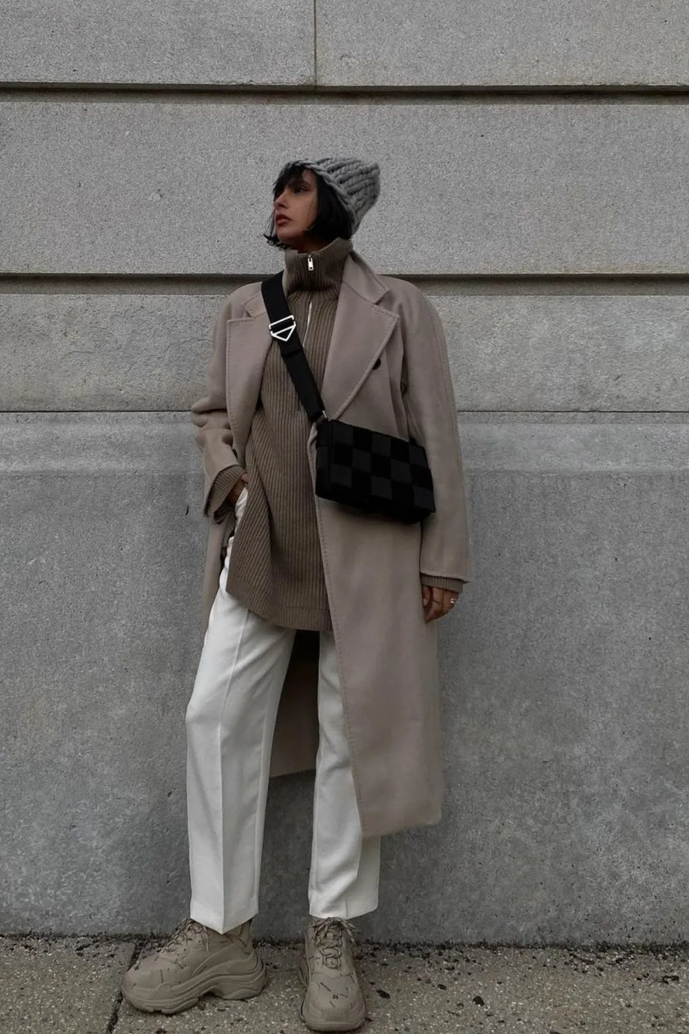 Oversize coat paired with white pants and long beige sweater