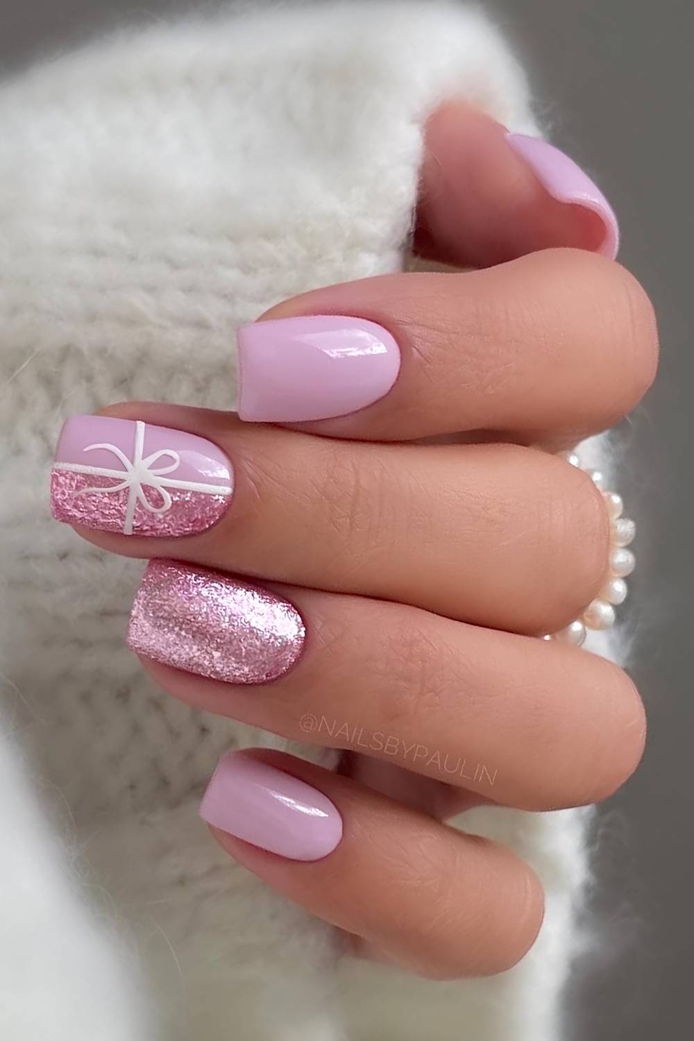 Pink Christmas nails with bows and glitter