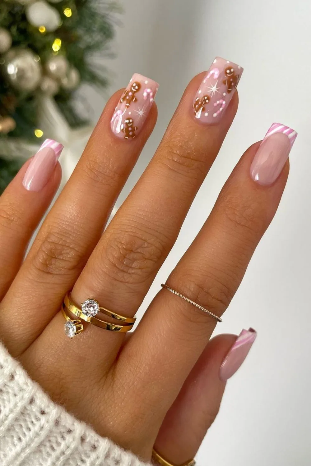 Pink and white french tips with tiney gingerbread and candy cane accents